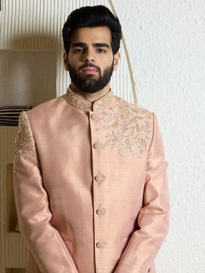 A portrait in the baby pink bandhgala, showcasing its soft, elegant, and refined character. The minimal threadwork adds a touch of warmth and sophistication.