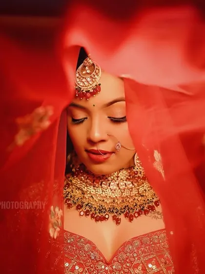 An artistic shot focusing on the bride's face through the movement of her veil, creating a soft and ethereal portrait.
