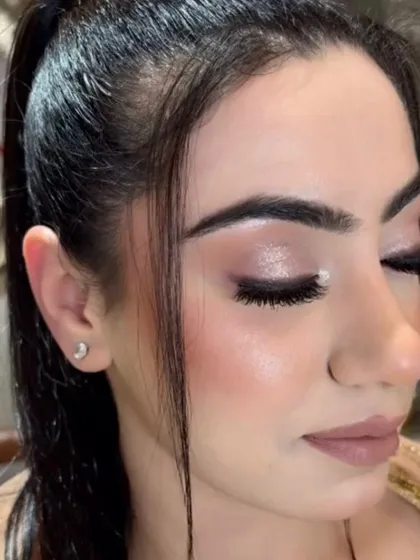 This close-up shows the detail of the shimmery eyeshadow and perfectly defined lashes, part of a soft glam party look.
