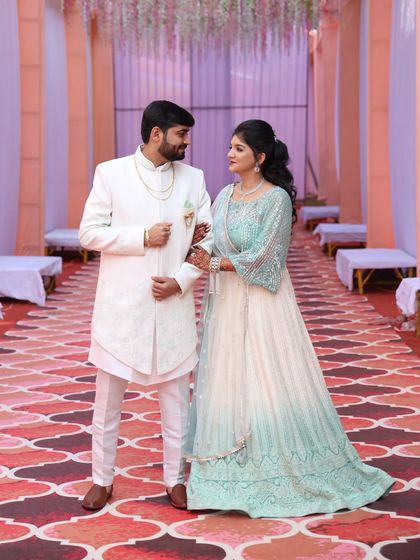 An elegant off-white Indo-Western outfit made from imported jacquard fabric. It's paired with a sleeveless inner jacket and matching trousers for a sophisticated, layered look.