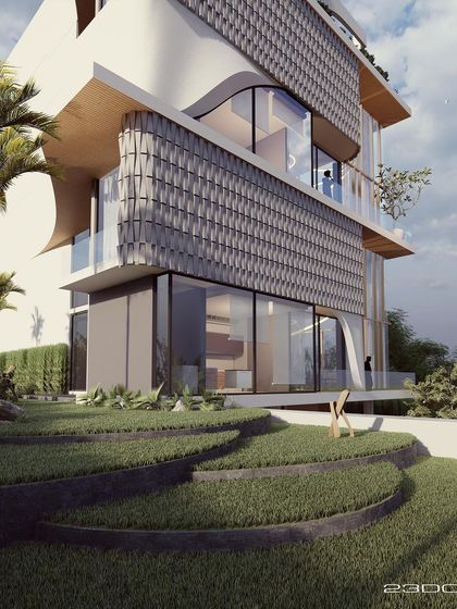 A view of the Jaipur residence from the garden, showing the stepped landscaping and the interplay of textures on the facade. The curved elements and glass walls create a dynamic and modern aesthetic.