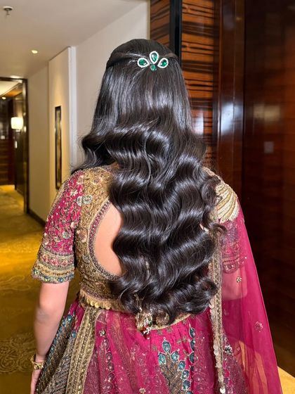 A detailed look at the Hollywood waves and emerald hair accessory that completed this bride's maroon majesty look, showing how hair and makeup work together.