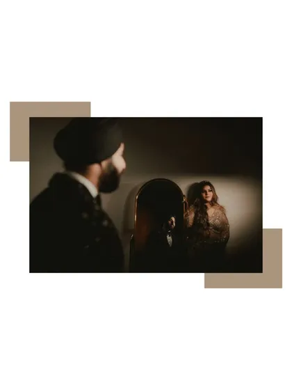 An artistic shot of the couple with a mirror, creating a moody and reflective portrait that speaks of intimacy.