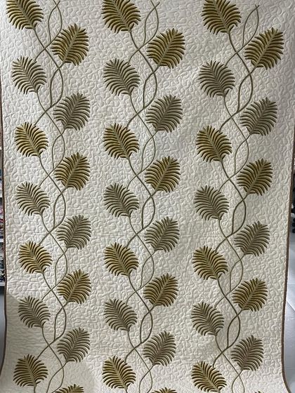 A beautiful quilt featuring delicate leaf appliqué.