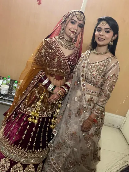 A beautiful moment between sisters. The bride is in a stunning maroon velvet lehenga and her sister is in an elegant ivory piece, both rented from my collection.