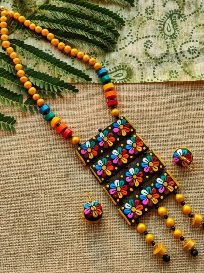 I love playing with colors, and this multi-layered floral necklace is a celebration of that joy. The design features four rectangular pendants adorned with 3D multicolor flowers, creating a vibrant cascade effect. It’s a cheerful piece that comes with cute, matching jhumkas.