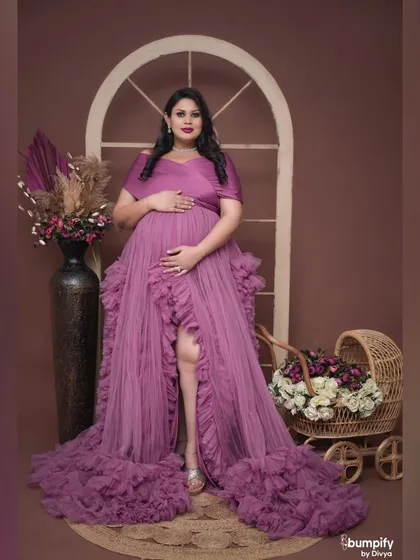 A beautiful solo portrait of the mom-to-be looking down at her bump, with the baby pram nearby. A quiet moment of connection with her baby.
