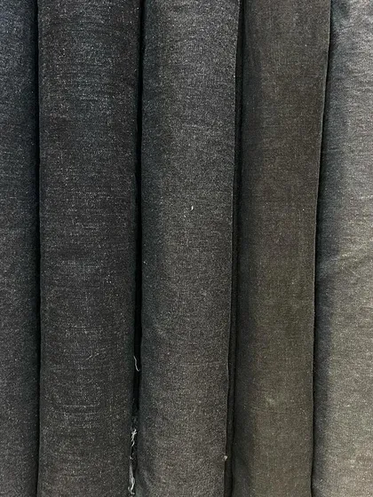 A collection of denim rolls in various shades of grey. From dark charcoal to light stone grey, you can find the perfect shade for your custom jeans or jacket.