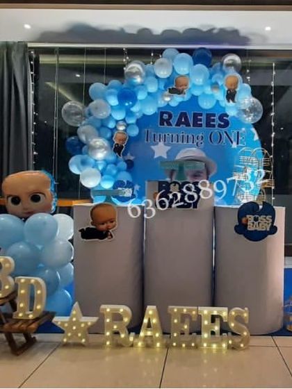 A Boss Baby theme for Raees' first birthday, featuring a custom backdrop, themed plinths, and a large illuminated number '1'.