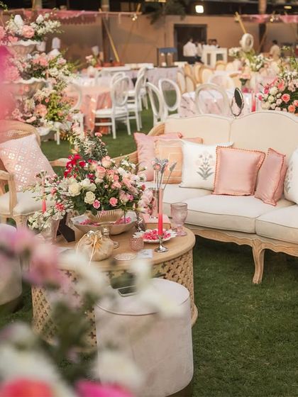 A comfortable lounge area at the 'Gulab Bagh' wedding, with custom-printed cushions and beautiful floral arrangements.