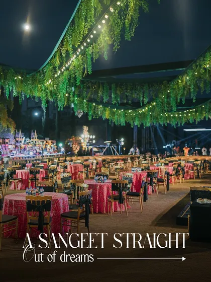 A Sangeet straight out of a dream. The ceiling is draped with lush greenery and fairy lights, creating an enchanted forest feel for this magical night of dance and music.