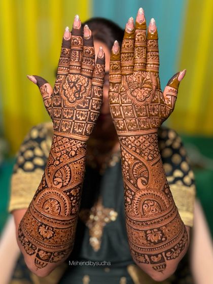 Rutuja's full bridal mehendi, with both hands displayed to show the complete, symmetrical design extending up the forearms.