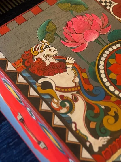 This angled view shows the mythical Yali, a protective figure often seen in temple architecture, painted alongside a vibrant lotus. It's these details that give each restored trunk its unique character and narrative depth.