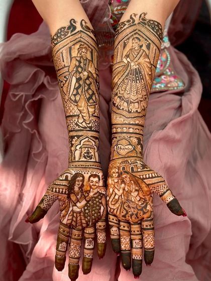 This mehndi is a beautiful family album, with portraits of the couple with their parents on the palms and a depiction of the bride and groom on the forearms.