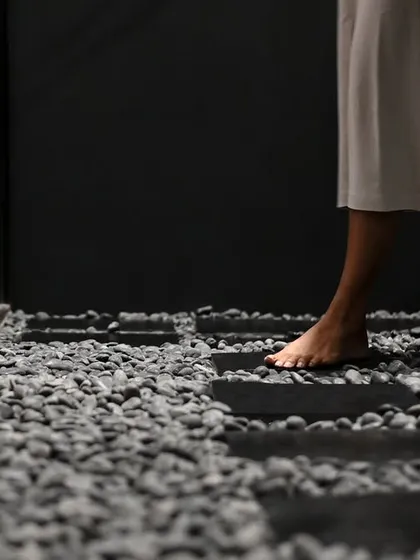 We believe architecture should engage the senses. For 'The Veiled Project', we used rough pebble stone flooring to intentionally slow a visitor's pace, encouraging a mindful, tactile experience of traversing the space and creating a transition to softer, quieter zones.