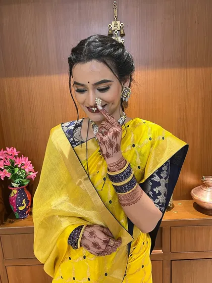 A playful and happy shot, showing off the intricate nose ring and the beautiful henna design.