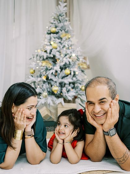 A family lying on the floor, full of smiles and laughter. A fun and relaxed holiday portrait.