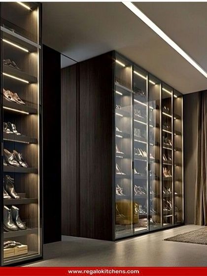 A full-wall shoe closet with angled, illuminated shelves and glass doors. This is the ultimate storage solution for the dedicated shoe aficionado.