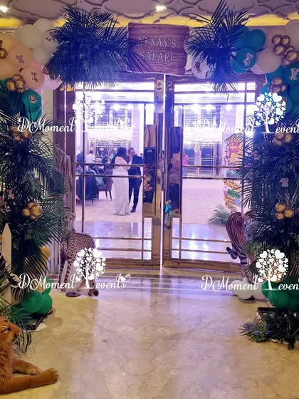 The entrance to the jungle safari, with lush palm tree props and animal cutouts creating an immersive experience from the start.