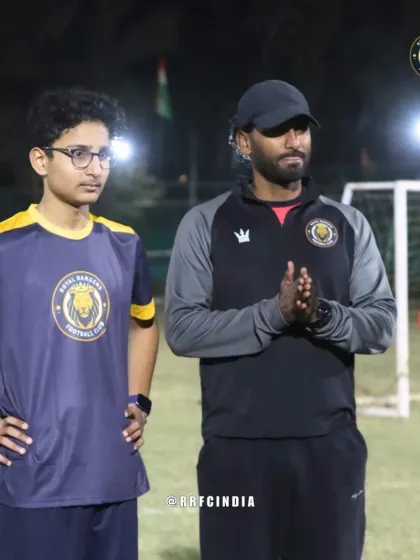 A coach observes a player during a night training session. We ensure every player receives attention and feedback to help them improve their game.