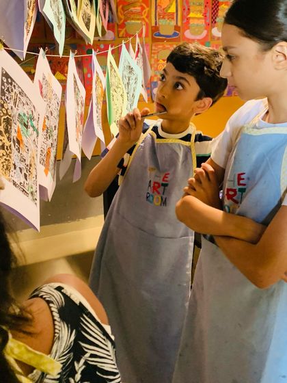 A young artist thoughtfully studies a collection of prints hanging in the studio. It is wonderful to see students find inspiration in each other's work and celebrate their collective creativity.