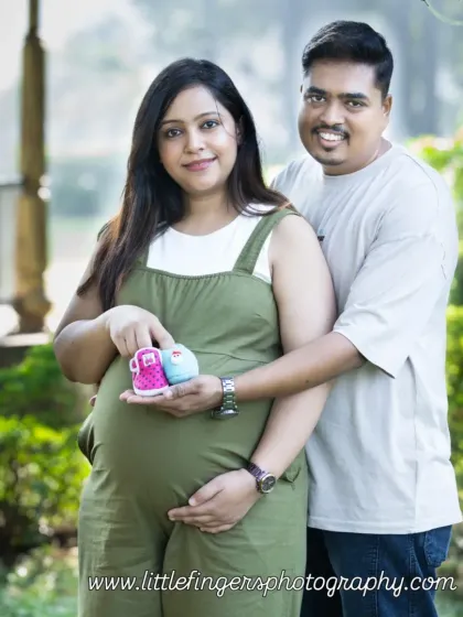 This couple, expecting twins, holds up one pink and one blue bootie. A wonderful way to celebrate the double joy coming their way.