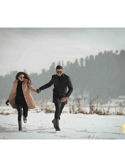 Another dynamic shot of the couple running hand-in-hand through the snow, capturing their joy and the beautiful winter scenery.