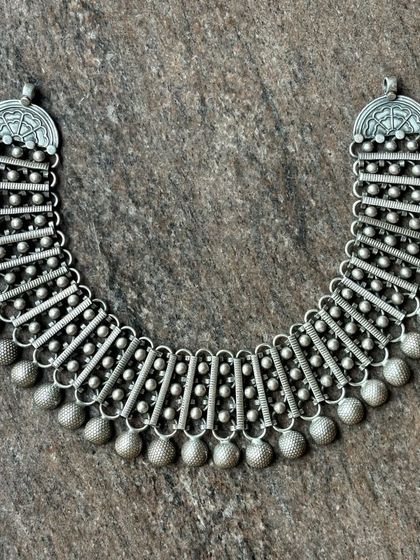 Another view of the multi-segment oxidised silver necklace, showing its flexibility and intricate construction.