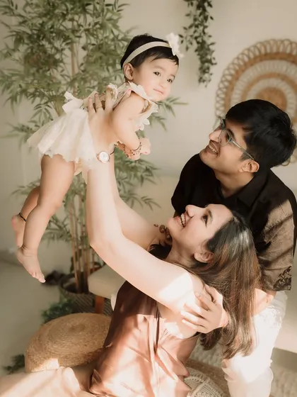 Flying high! A fun and dynamic shot of the parents lifting their daughter in the air.