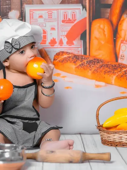 A healthy appetite for fun. This close-up shot shows the baby interacting with the toy fruits, a perfect example of the cute and spontaneous moments we aim to capture.