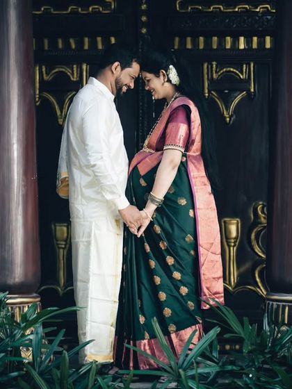 An intimate maternity photo in traditional attire against our ornate, dark wood pillars.