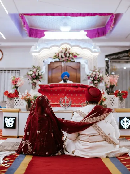 A serene and powerful shot from behind the couple as they sit before the Guru Granth Sahib during their Anand Karaj ceremony.