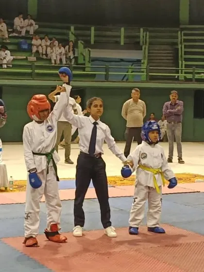 A referee declares the winner in a junior sparring match at the Bengal State Championship.