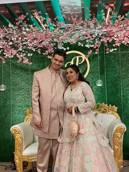 The happy couple posing against their beautiful stage backdrop. Their smiles say it all.