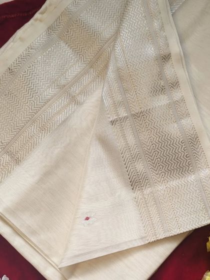 A closer look at the Onam Edit Maheshwari silk cotton saree. The off-white body is adorned with tiny red and silver Meenakari buttis.