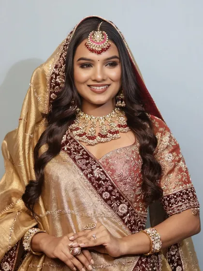 A radiant smile from a bride adorned in the 'Riwayat' look. The makeup enhances her features while the dupatta frames her face, creating a picture of timeless bridal grace.