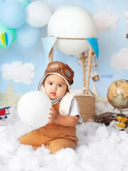 This little traveler is ready to explore the world. The globe and vintage airplane props add a lovely touch to this adventure-themed photoshoot.