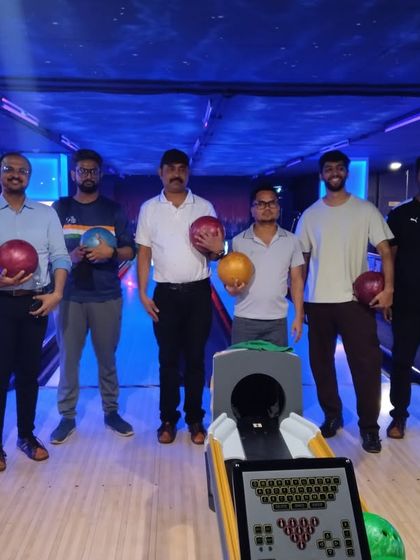 The finalists of our bowling league are all set for the final showdown, holding their bowling balls and ready to compete.