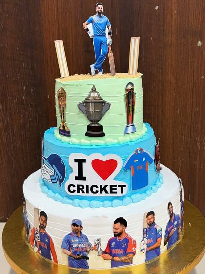 For the ultimate cricket fan, a 5kg, 3-tier cricket theme cake. This vanilla sponge with chocolate cream cake features Virat Kohli, team jerseys, and trophies, celebrating a love for the sport.