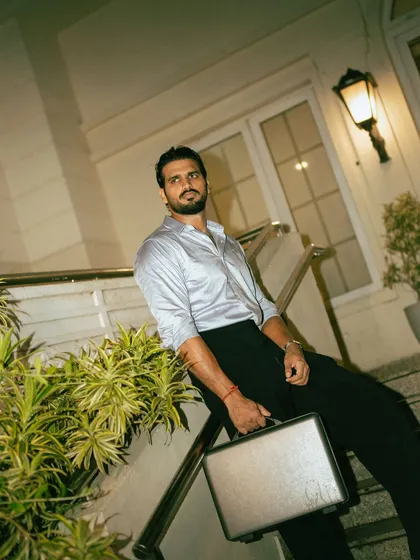 An evening on-location shoot, using architectural lighting to create a sophisticated atmosphere. The model's pose on the staircase with a briefcase tells a story of a modern professional.