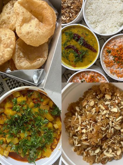 A traditional meal of fluffy Puris, Aloo Sabzi, Dal, Boondi Raita, and Lapsi for dessert.