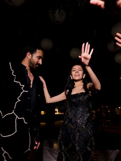 A candid shot of the couple dancing, their coordinated black outfits perfect for a high-energy cocktail night.