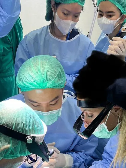 A team of doctors fully engaged in a hands-on hair transplant procedure. My workshops emphasize teamwork and shared learning, mirroring a real clinical setting.