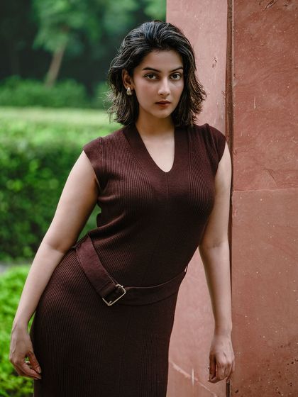 This outdoor fashion portrait uses a strong, direct pose to create a commanding presence. The model's intense gaze and the simple, elegant dress make this a powerful image for a portfolio or brand campaign.