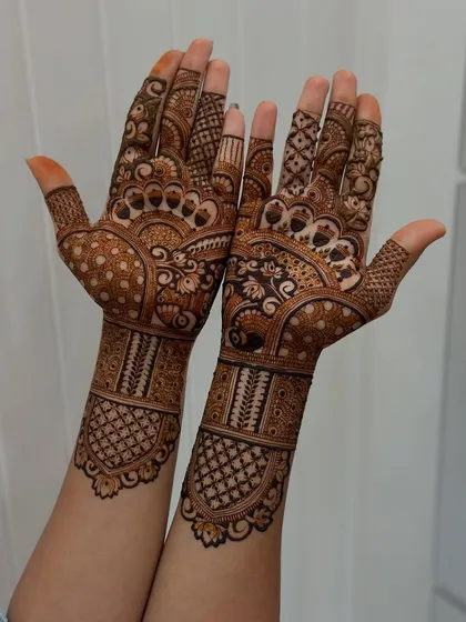 The intricacy here is just fantastic. From the detailed fingertips to the wrist cuffs, this student's work shows a comprehensive understanding of bridal mehendi design principles.