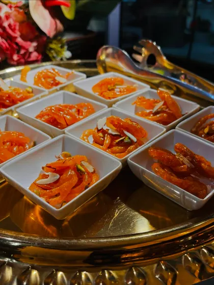 Freshly made Jodhpur Jalebis, served hot in individual portions. These crispy, syrup-soaked swirls are a crowd favorite, and their preparation at a live counter is always a treat to watch.