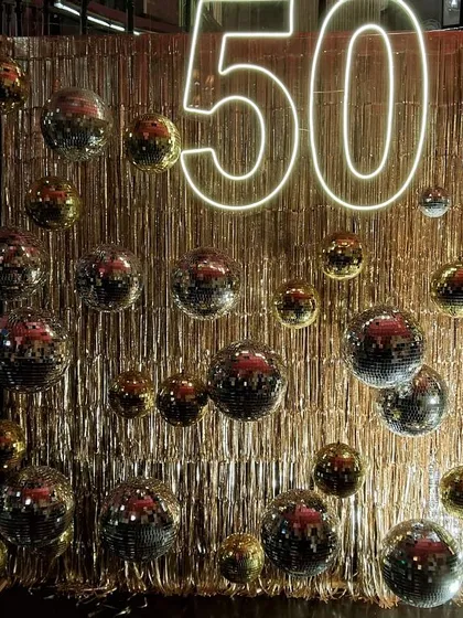The way the light hits the disco balls and gold fringe is just magical. This setup was designed to sparkle and shine from every angle, creating a truly immersive and celebratory experience.