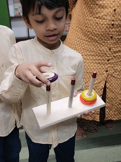 A young participant mastering the Tower of Hanoi, a classic puzzle that requires logic and problem-solving. It's wonderful to see kids so focused and determined during these sessions.