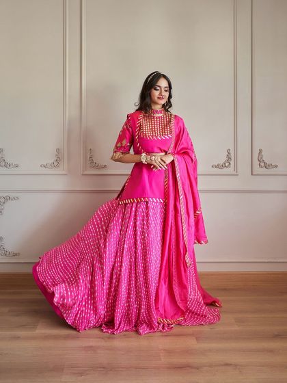 A full-length shot of the Rajputani-style outfit, showing the detailed gota patti work and the beautiful flare of the leheriya skirt.