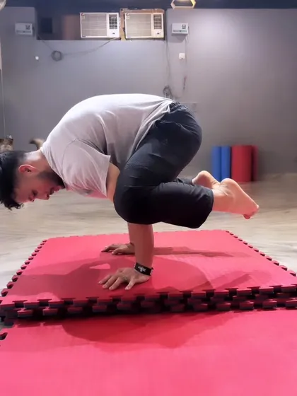 An adult student holds a perfect Bakasana, or Crow Pose, on the mats. This is a great example of the calisthenics and bodyweight strength training we focus on in my gymnastics sessions to improve balance and core power.